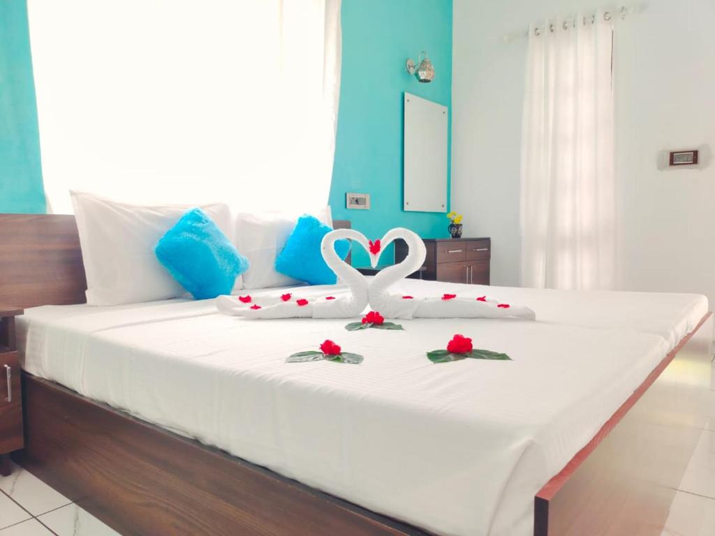 Un dormitorio con una cama con un corazón y flores. en Marari La Rose Beach Homestay, en Mararikulam