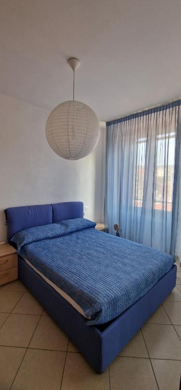 ein Schlafzimmer mit einem blauen Bett mit blauer Decke in der Unterkunft Bicycle road in Imperia