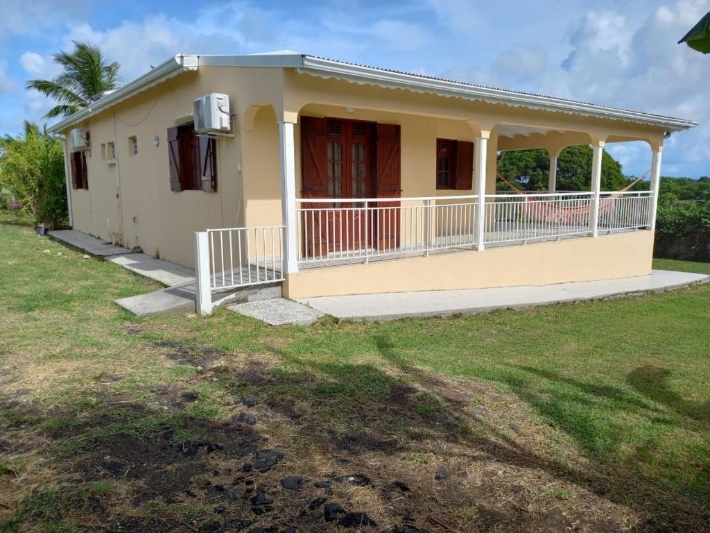 a small yellow house with a porch at Villa Odette in Beauséjour