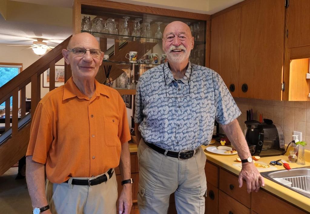 two older men are standing in a kitchen at Burken B&B in Brighton