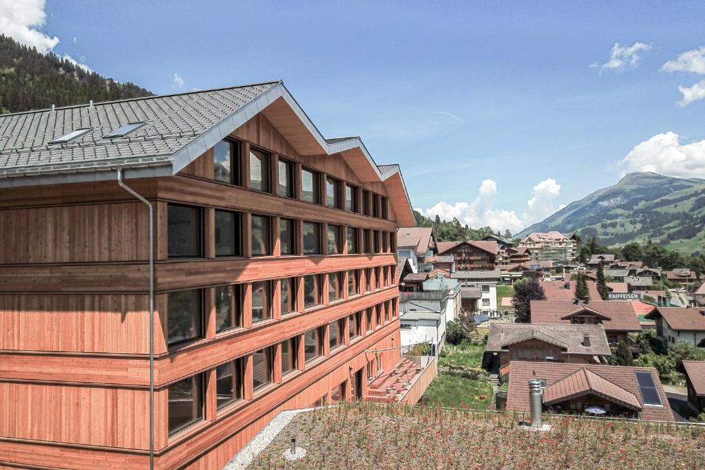 uma casa de madeira com vista para uma cidade em Revier Mountain Lodge Adelboden em Adelboden