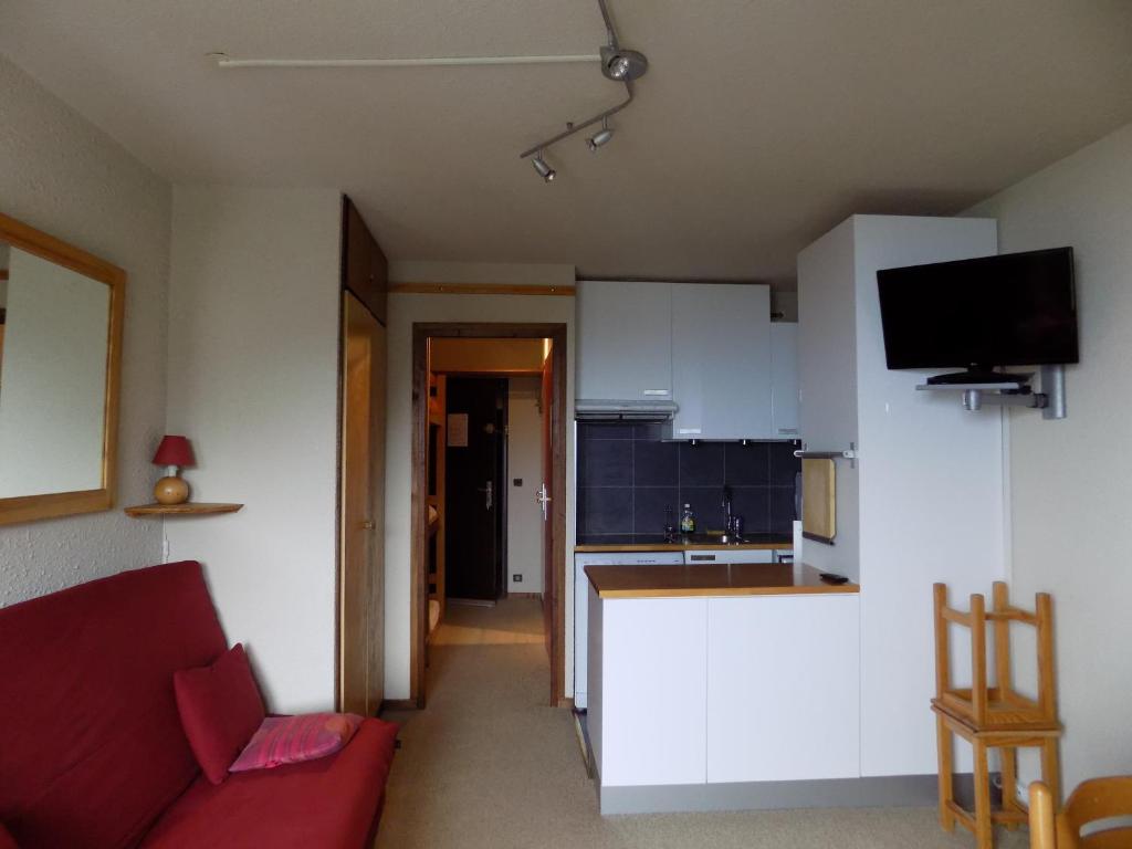un salon avec un canapé rouge et une cuisine dans l'établissement Studio Les Orres 1650, aux Orres