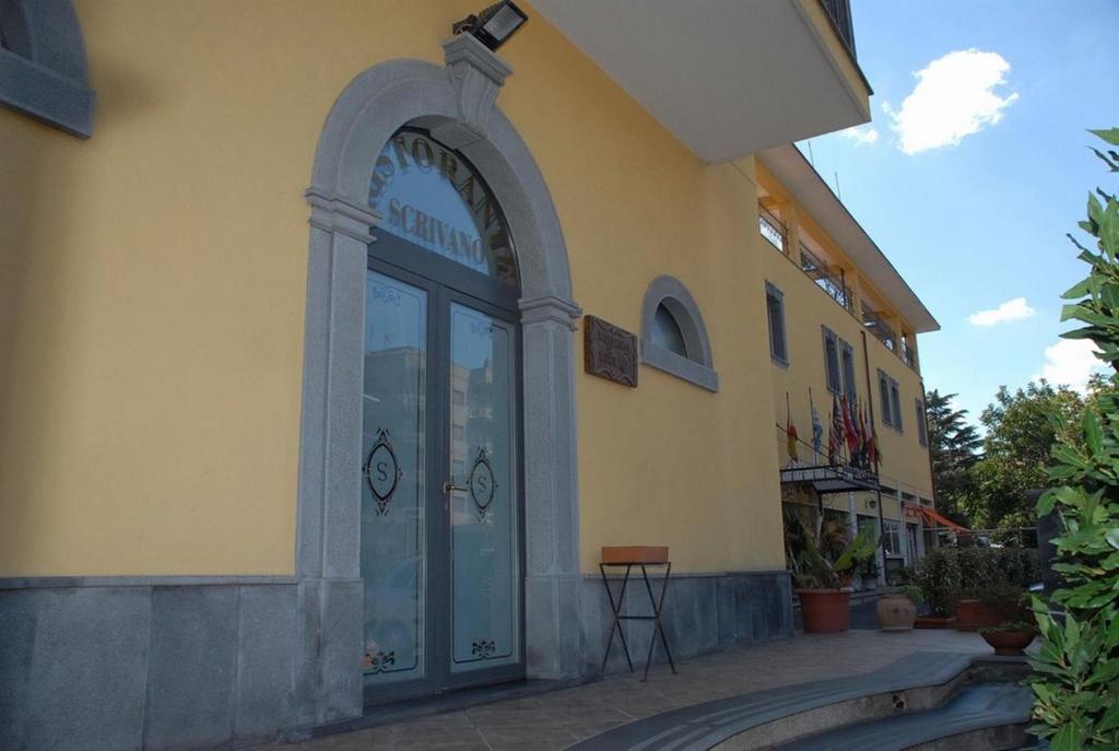 ランダッツォにあるHotel Scrivanoの大きなガラス戸付きの建物の入口