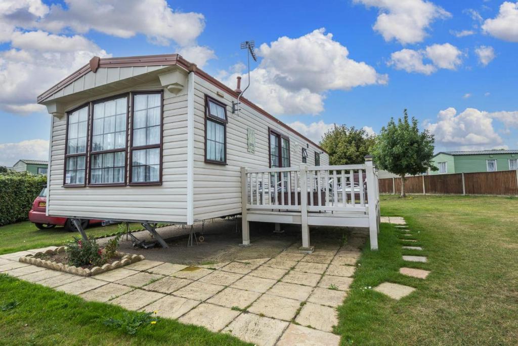 ein kleines weißes Haus mit einem großen Fenster in der Unterkunft Great 6 Berth Caravan For Hire At Cherry Tree Holiday Park In Norfolk Ref 70801c in Great Yarmouth