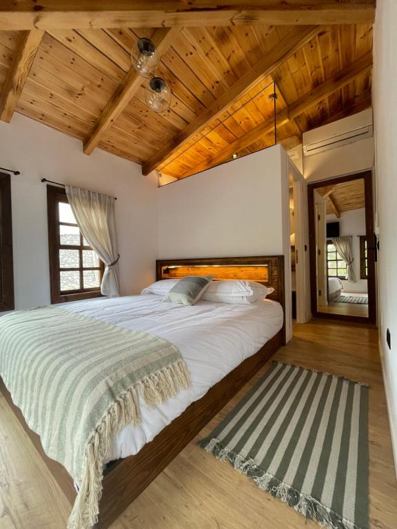 a bedroom with a large bed and wooden ceilings at N'Gorice in Berat