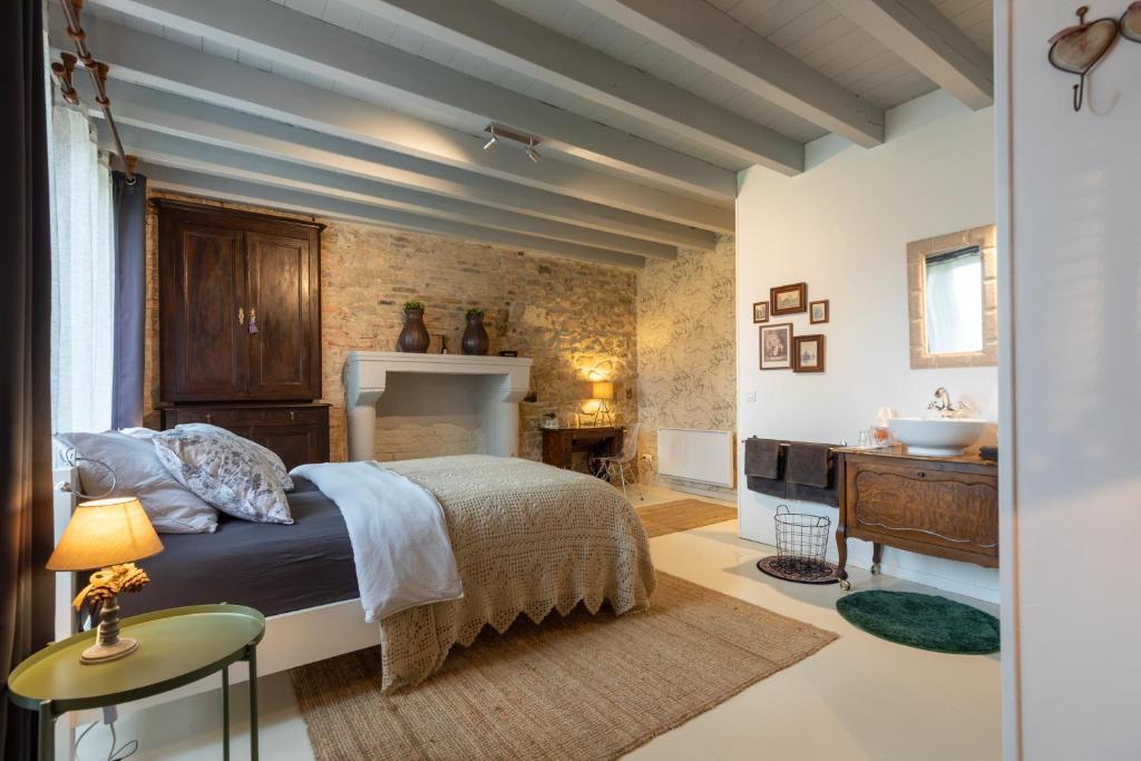 1 dormitorio con 1 cama y lavamanos. en Domaine La Pomme de Pin, en Louroux-de-Beaune
