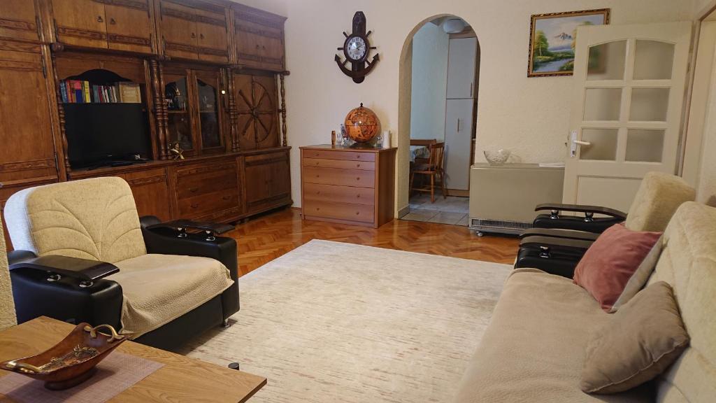 a living room with a couch and chairs and a tv at Apartment 4 Kullat in Prizren