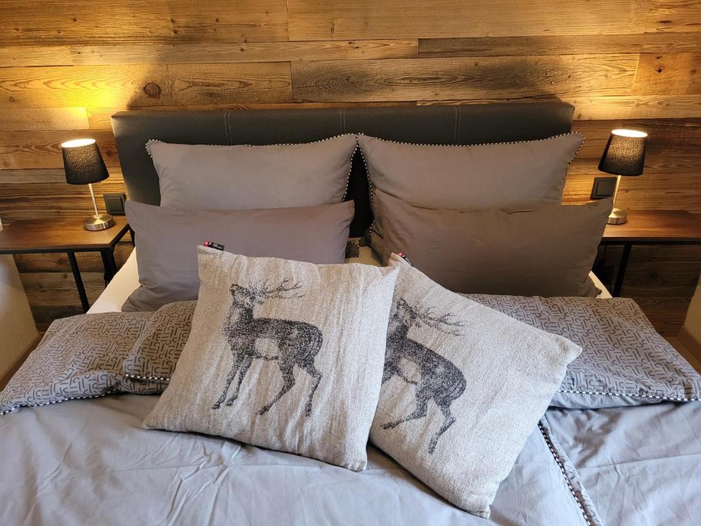 ein Bett mit zwei Hirschkissen drauf in der Unterkunft Familienfreundliche großzügige Ferienwohnung Schlierachwelle zwischen Schliersee und Tegernsee in Hausham