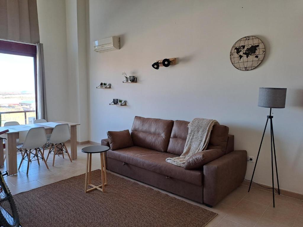 sala de estar con sofá marrón y mesa en Acogedor loftcon garaje a 10min del aeropuerto, en Madrid