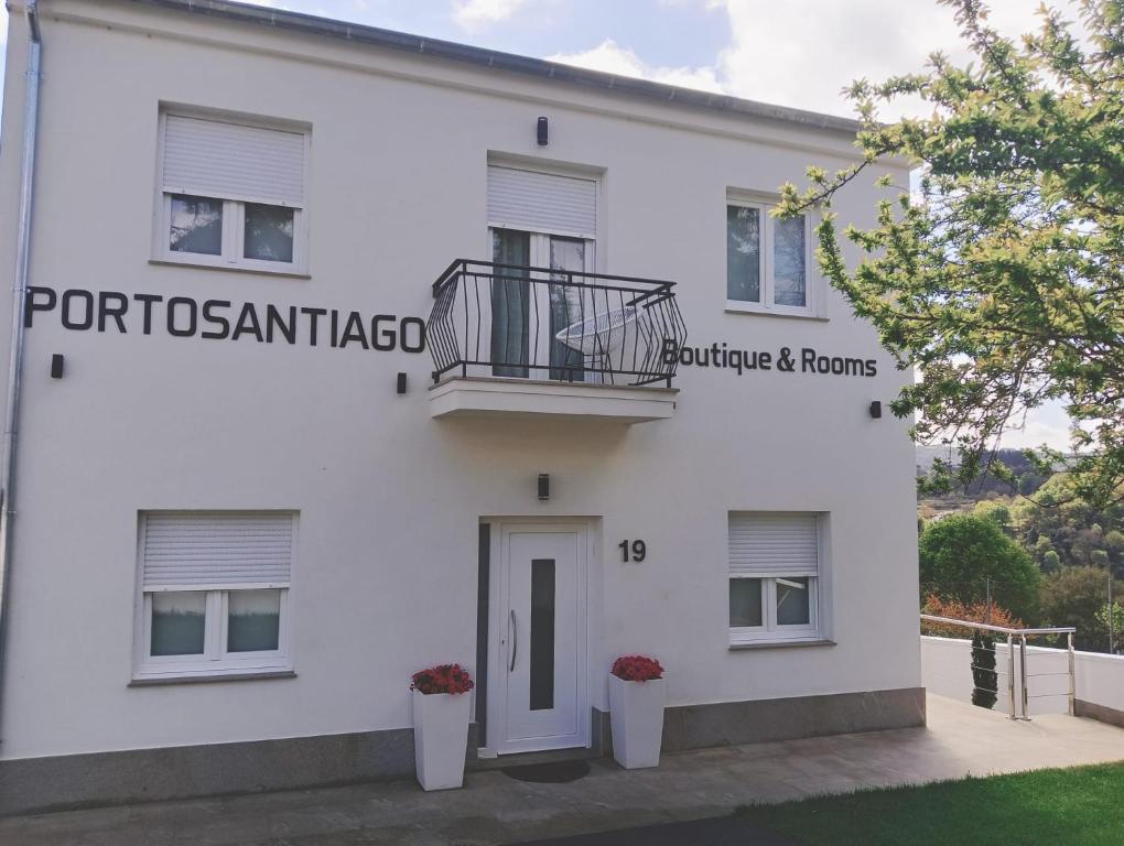 un edificio blanco con un balcón en el lateral en PortoSantiago Boutique & Rooms, en Portomarín