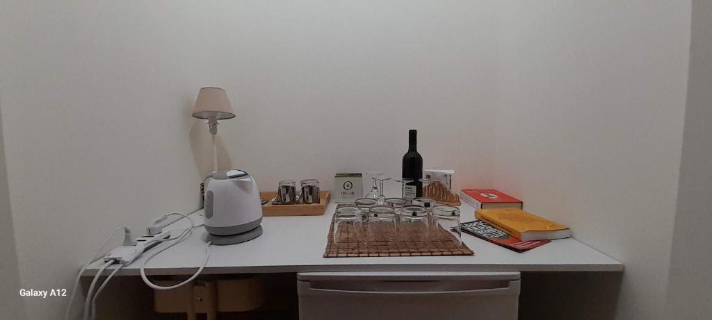 una mesa blanca con una botella de vino y una licuadora en Trieste Mia Rooms en Trieste