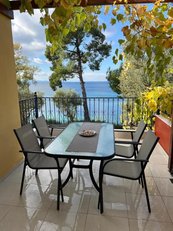 una mesa y sillas con vistas al océano en Seafront Loft - Akti Elia, en Nikiti