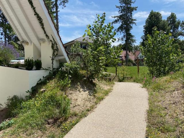 einen Fußweg neben einem Haus mit Bäumen und einem Haus in der Unterkunft La Garrigue, au milieu des pins maritimes... in Cucq