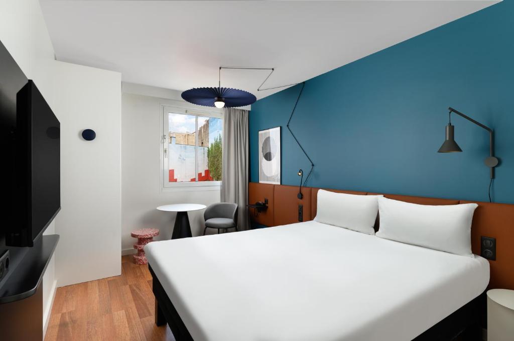 ブダペストにあるイビス ブダペスト セントラムのベッドルーム1室(白いベッド1台、青い壁付)