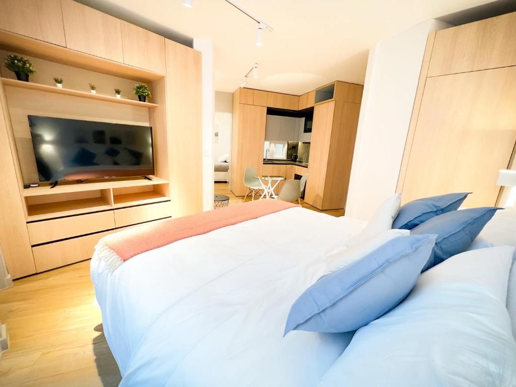 a bedroom with a large white bed with blue pillows at HOM l Departamento 3PAX A l A Lastarria in Santiago
