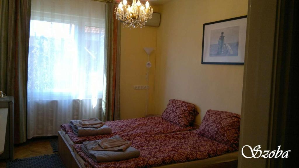 オロシュハーザにあるMosoly Vendégházのベッドルーム1室(ベッド1台、椅子、窓付)