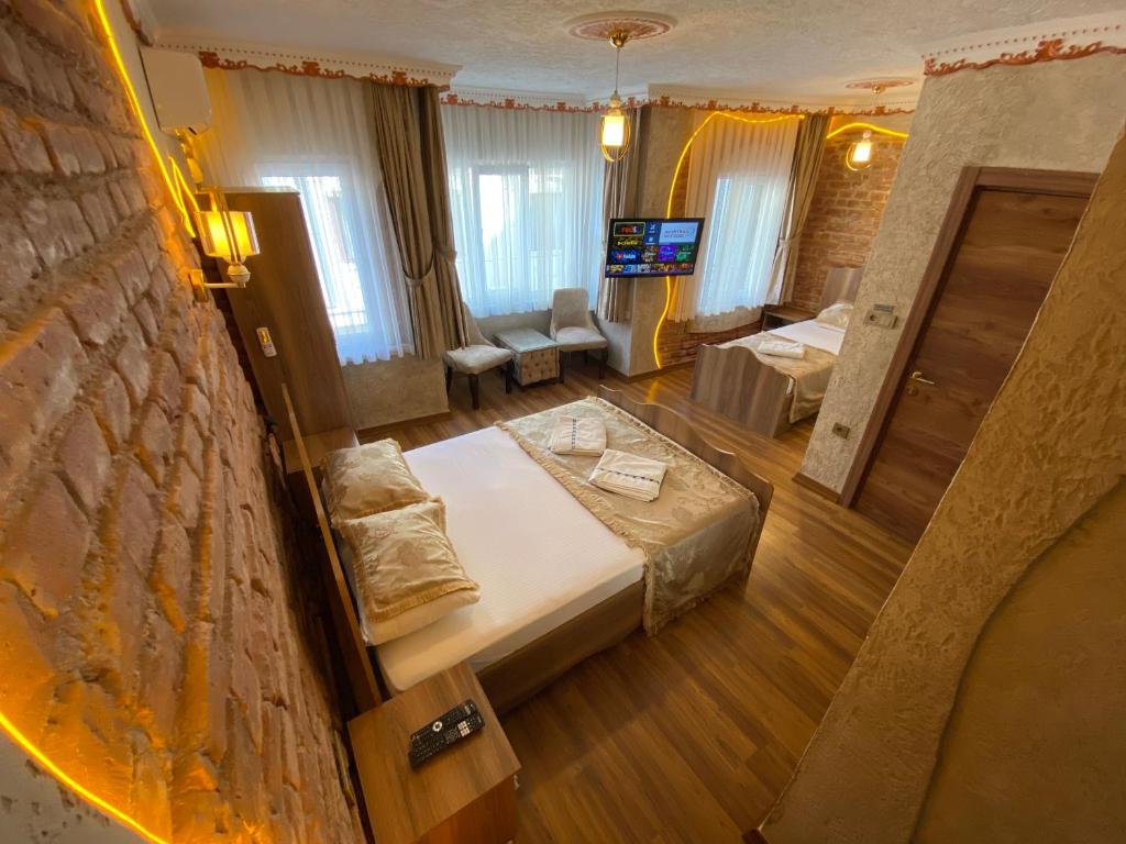 una camera con due letti e una televisione in esso di GOLDEN ARROW OLD CİTY HOTEL a Istanbul