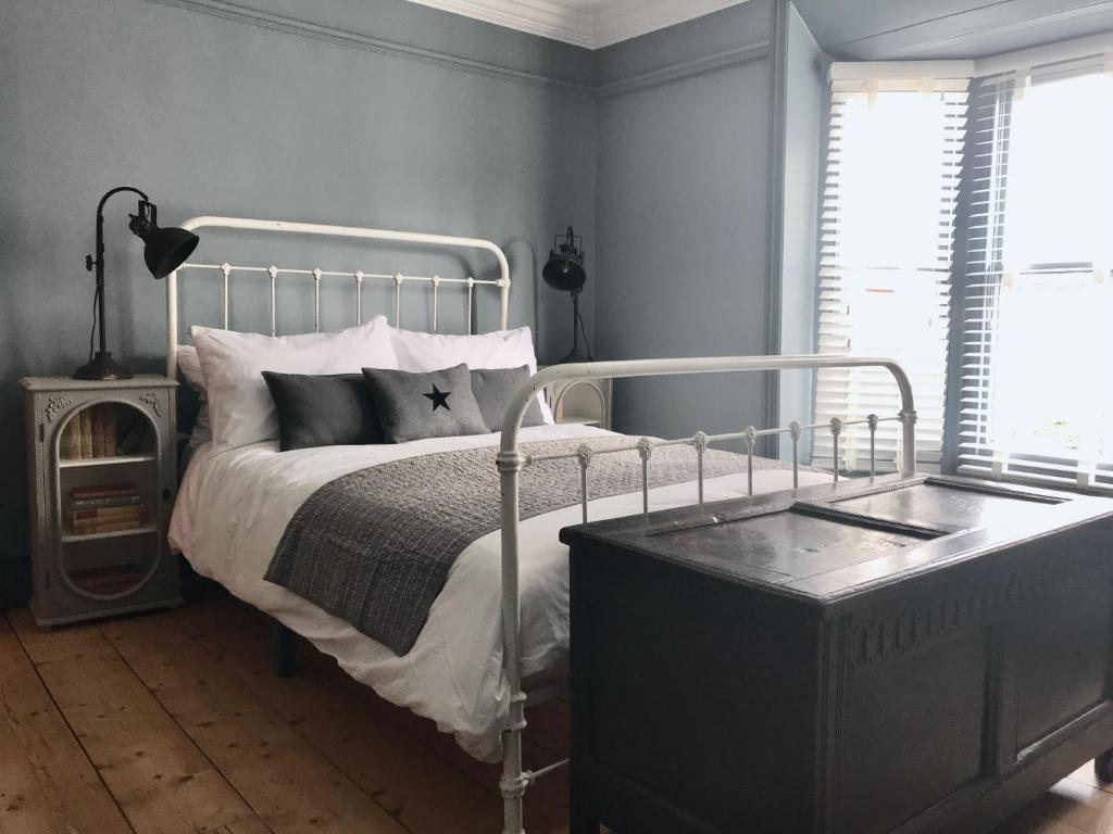 sypialnia z łóżkiem z metalową ramą w obiekcie Stunning seaside cottage seconds from beach by Whitstable-Holidays, Fig Cottage w mieście Whitstable
