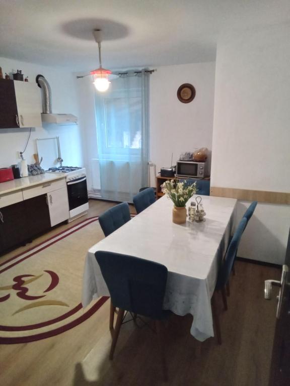 uma cozinha e sala de jantar com uma mesa branca e cadeiras azuis em Casa Ozon em Vulcan