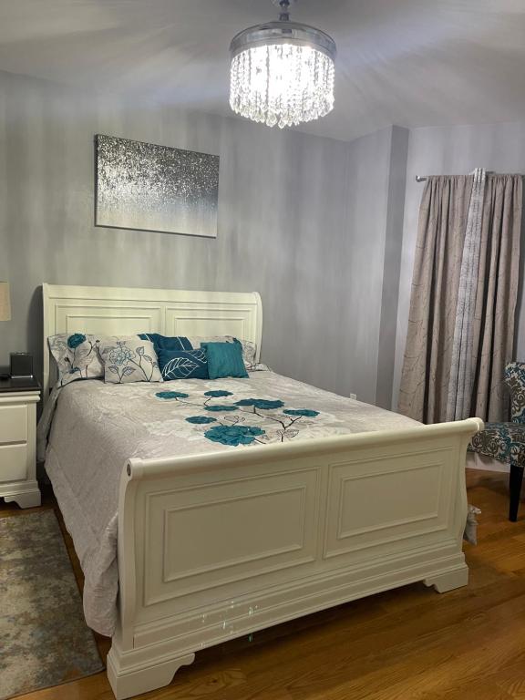 a white bed in a bedroom with a chandelier at Brand New Luxury Rooms near downtown Boston in Boston
