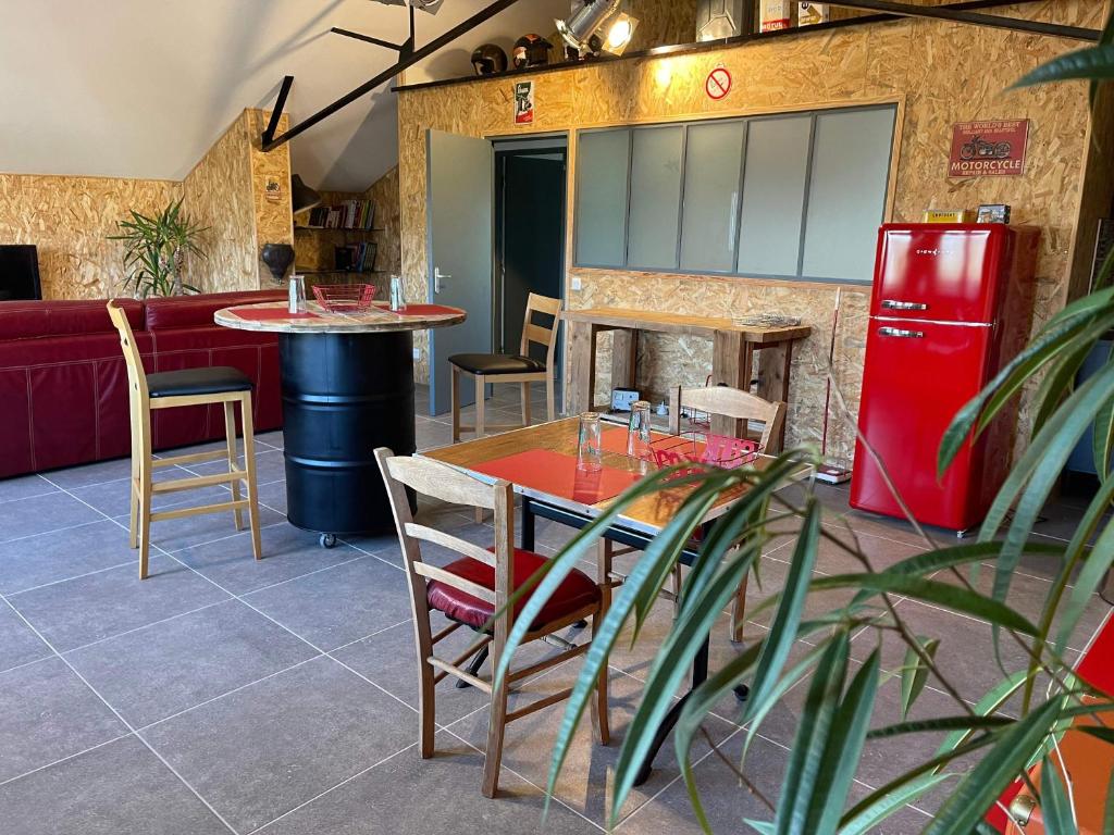 een restaurant met een tafel en een rode koelkast bij L'échappée flamande in Hazebrouck