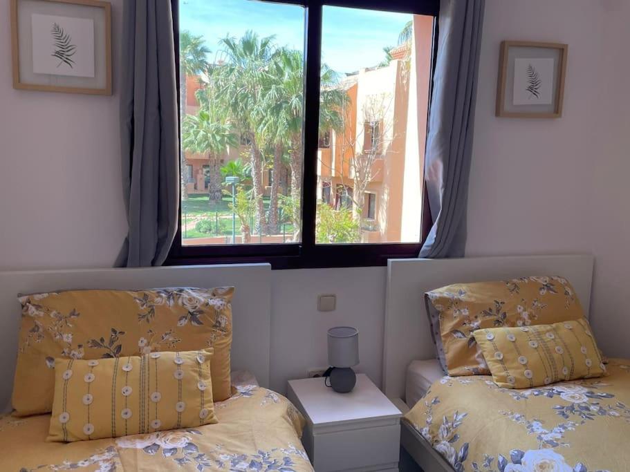 1 dormitorio con cama y ventana en Casa Estrellita - Lovely beachside 3 bedroom duplex flat, en Los Alcázares