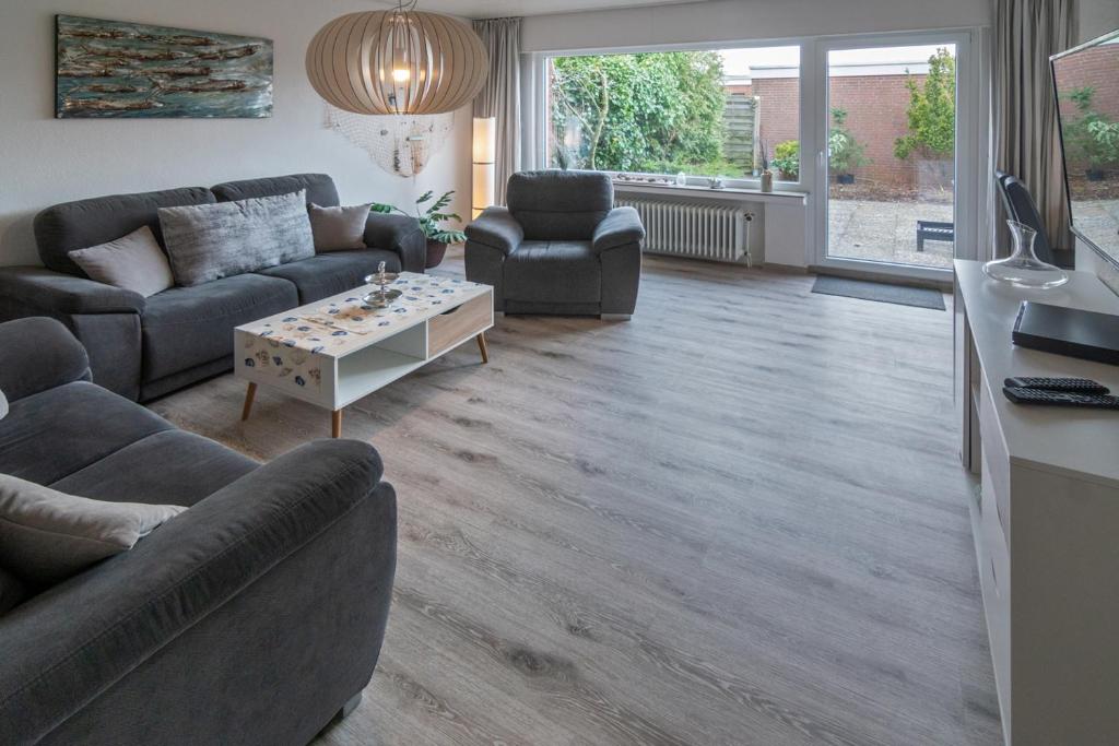 a living room with two couches and a table at Ferienhaus Neptun Norddeich in Norddeich