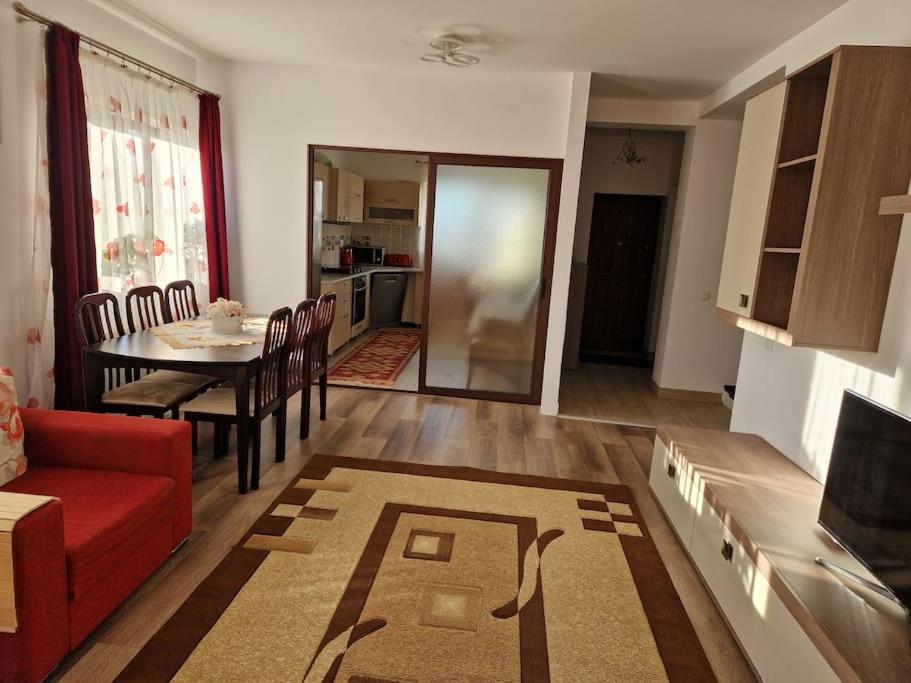 a living room with a red couch and a table at Casă și curte confortabilă in Braşov