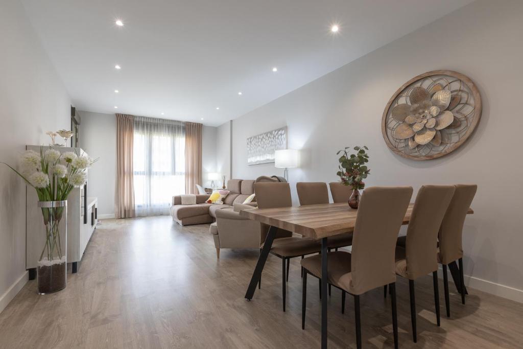 a dining room and living room with a table and chairs at Los Alamos Beach Flat in Torremolinos