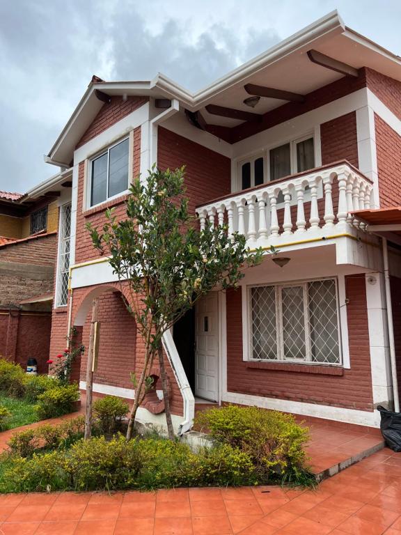 una casa de ladrillo rojo con un adorno blanco en Hermosa y cómoda casa en Cochabamba en Cochabamba