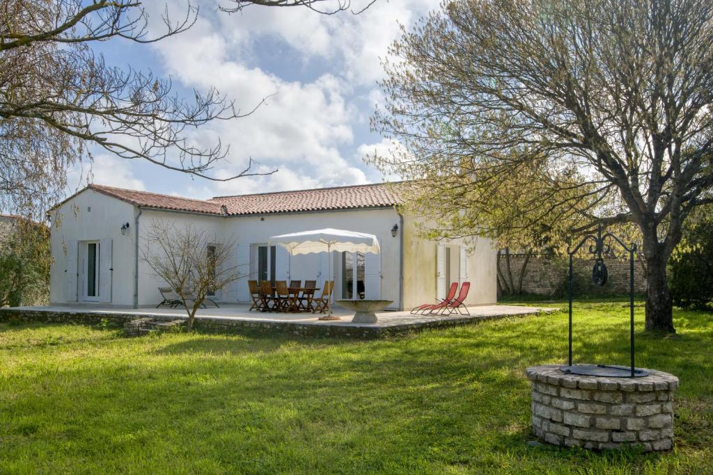 a small white house with a grass yard at Villa PIERROT avec grand jardin arboré, proche du port et des restaurants in La Flotte