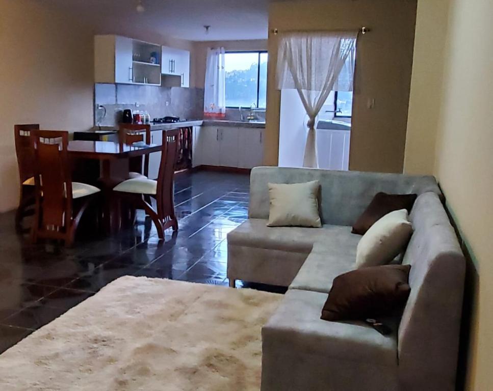 sala de estar con sofá, mesa y cocina en Departamento en Cuenca, 2 habitaciones y parqueo gratis, en Cuenca