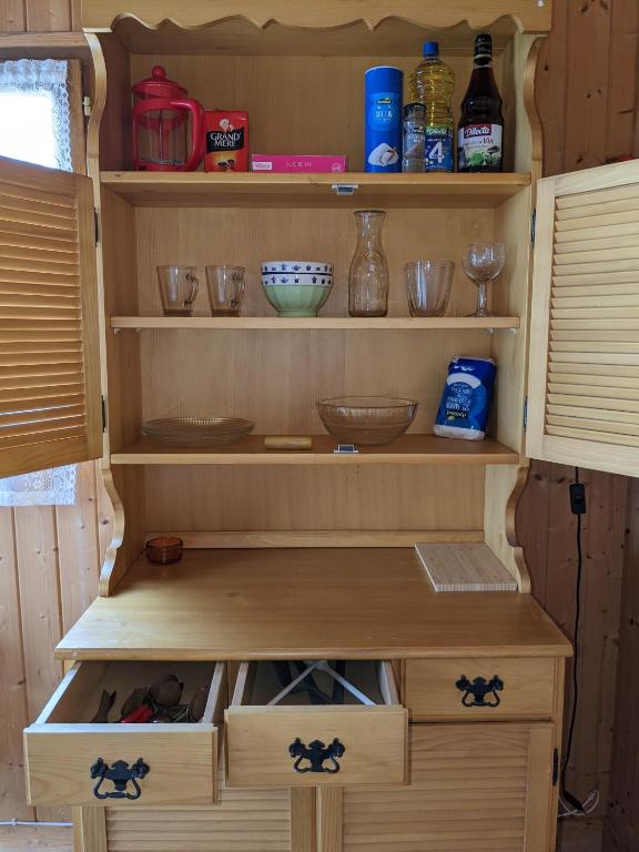 a cupboard with bowls and other items on it at Au petit chalet d&#39;Illiers Combray in Illiers