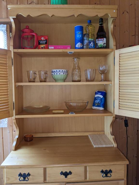 a wooden shelf with bowls and other items on it at Au petit chalet d&#39;Illiers Combray in Illiers