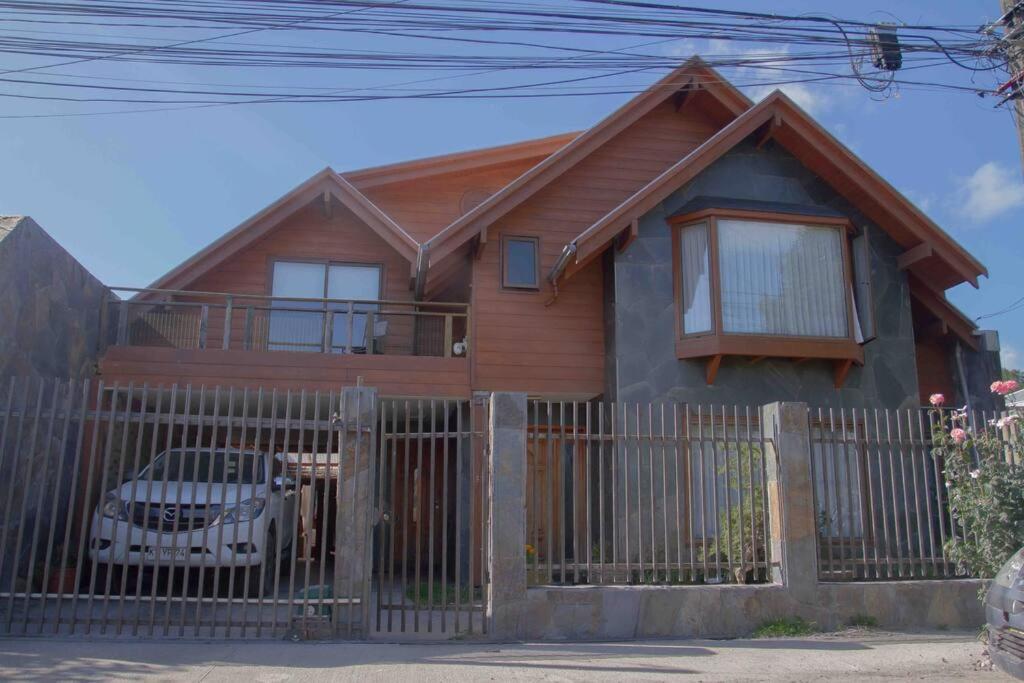 una casa con una valla de madera delante de ella en Casa céntrica por día en Pucón en Pucón