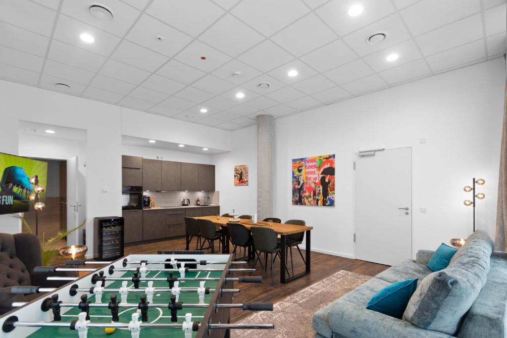 a living room with a foosball table and chairs at Flatista Homes - Aubing in Munich