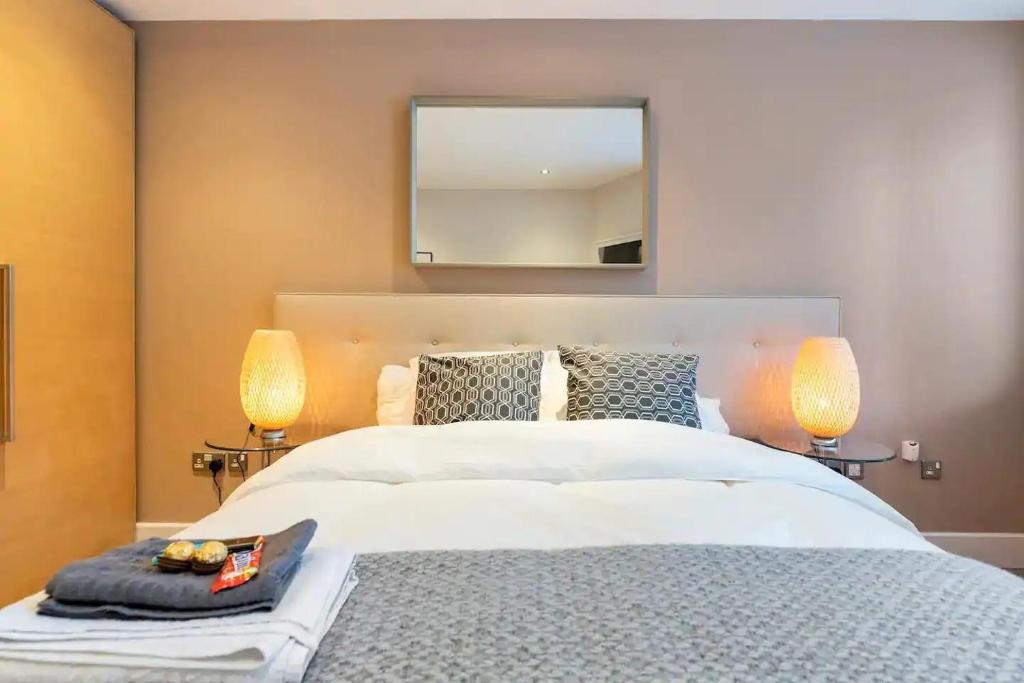 a bedroom with a large white bed with two lamps at Cosy and modern Bedroom in the heart of Dublin in Dublin