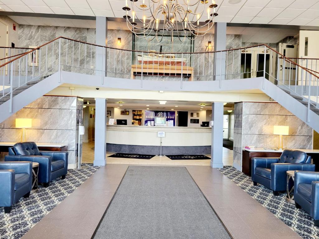 a lobby with blue chairs and a staircase at Bangor Grande Hotel in Bangor
