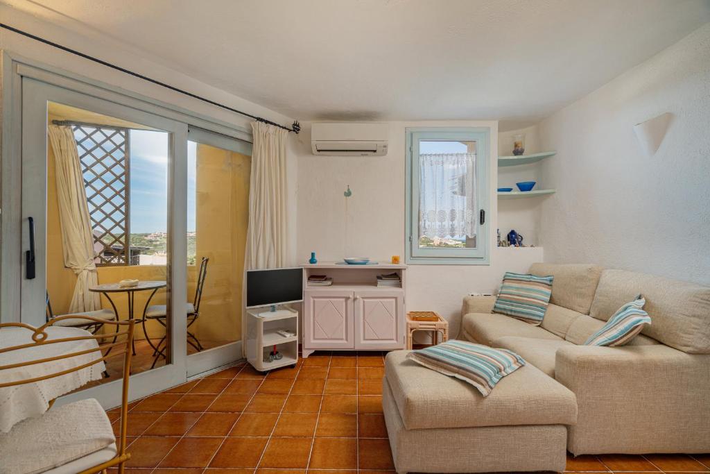 Una sala de estar con un sofá y un televisor. en Casa Lilly by Wonderful Italy, en Porto Cervo