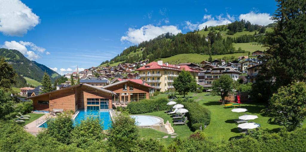 a resort in the mountains with a swimming pool at Family Hotel Posta in Santa Cristina in Val Gardena