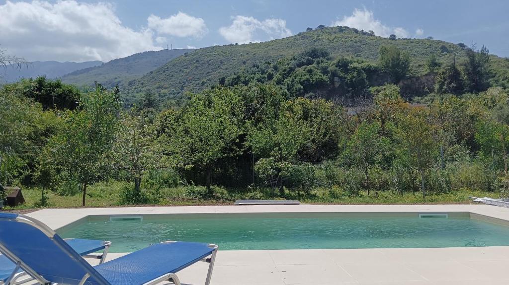 una piscina con 2 sillas y una montaña en Villa Evridiki, en Georgioupolis