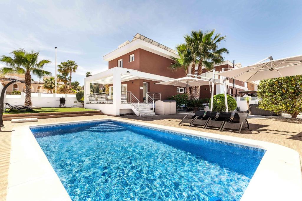 a villa with a swimming pool in front of a house at Casa Bos Orange Wellness Luxury Entire Villa Jacuzzi & Pool Gran Alacant near Beach in Puerto Marino