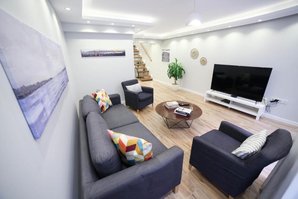 ein Wohnzimmer mit 2 Sofas und einem Flachbild-TV in der Unterkunft Modern Super Chic Duplex with a Terrace at the heart of city! in Istanbul