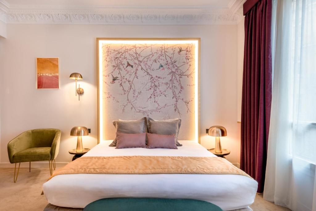 een slaapkamer met een groot bed met 2 kussens bij Princesse Caroline in Parijs