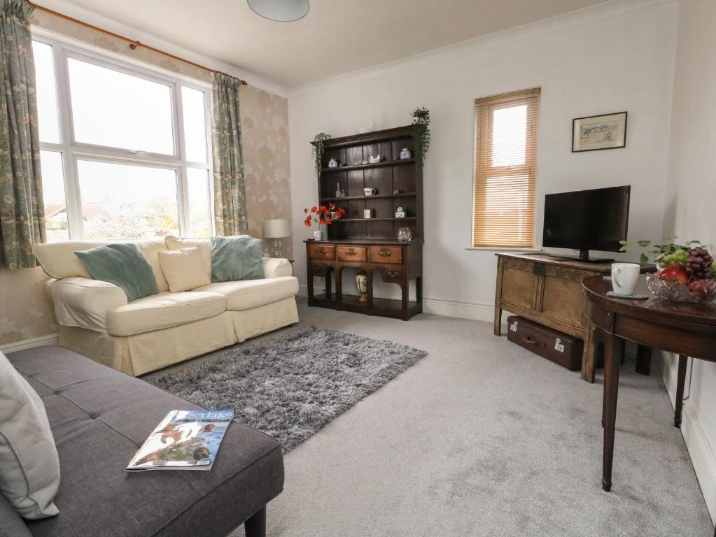 a living room with a couch and a television at Victoria Court in Weymouth