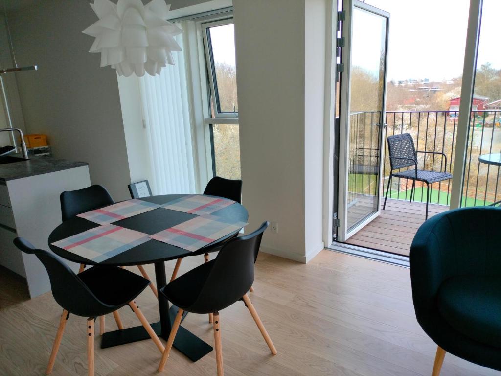 a table and chairs in a room with a balcony at Ny bolig i grønne omgivelser. in Rødovre