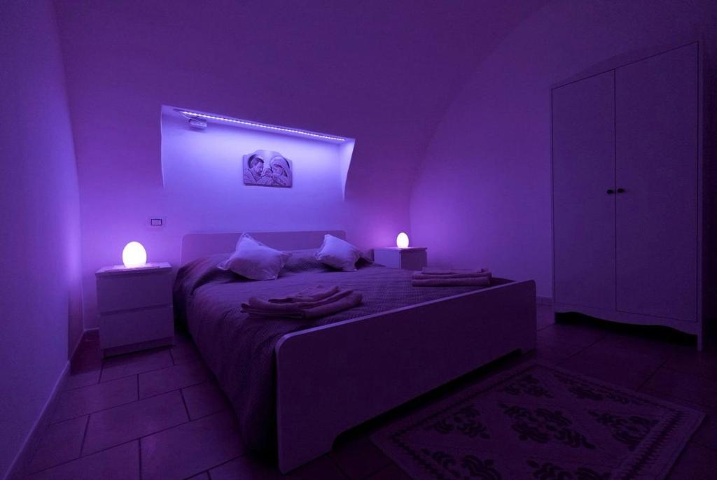 a purple room with a bed with two lights on it at La casa di mammina in Bari