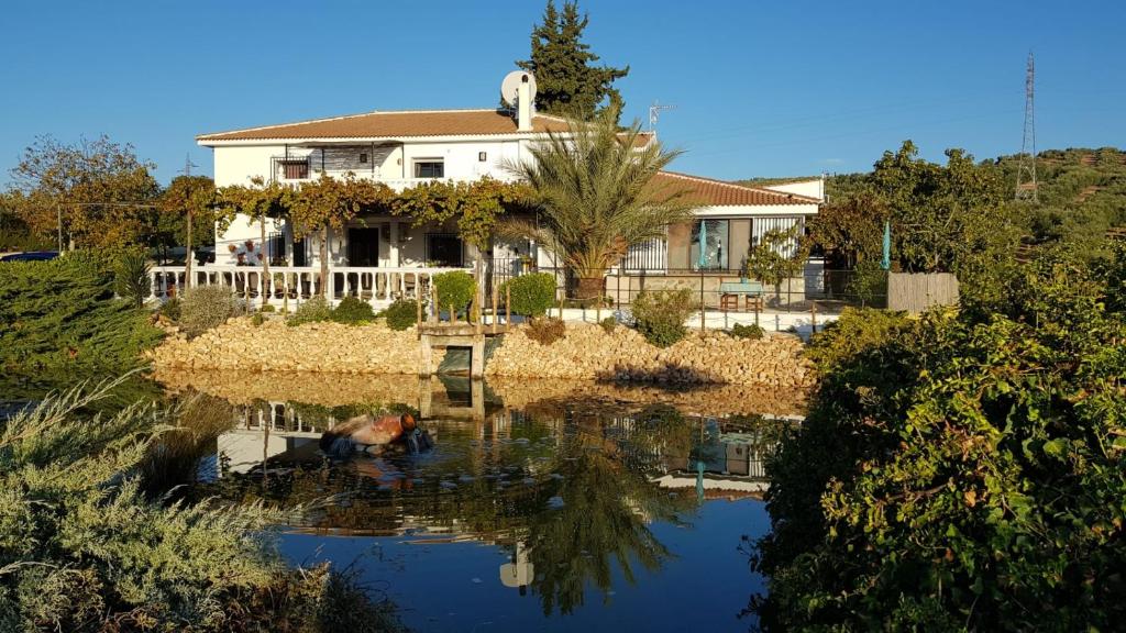 una casa se refleja en el agua de un lago en Casa Olivar B&B, en Tocon