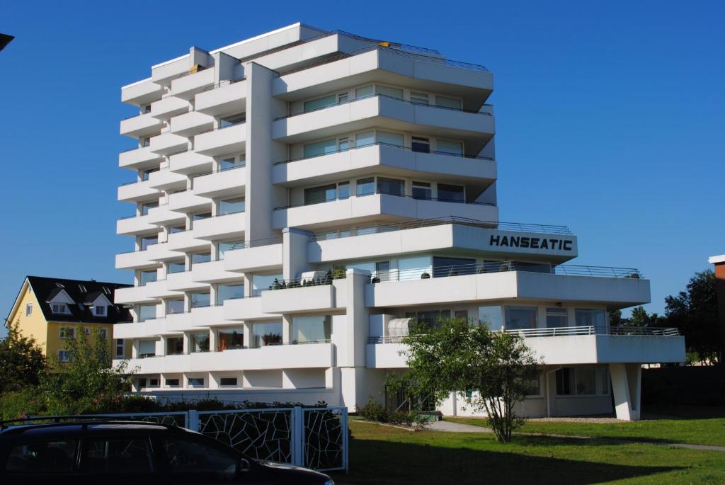 un immeuble blanc avec une pancarte dessus dans l'établissement Haus Hanseatic, Wohnung 312, à Duhnen