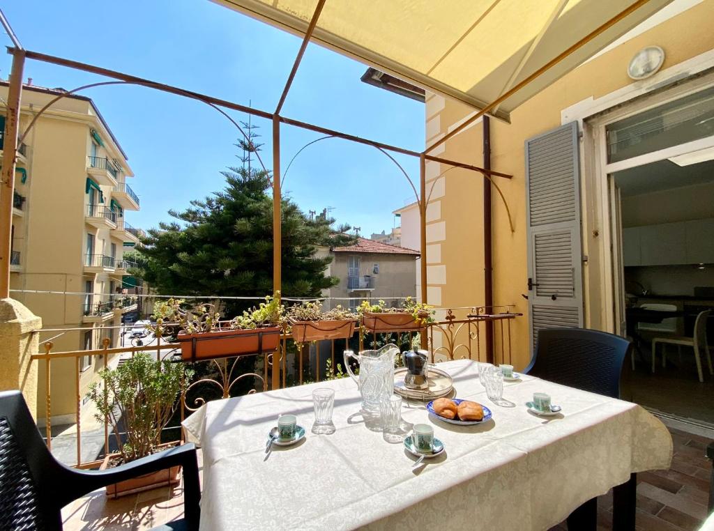een tafel met een bord eten op een balkon bij Hostdomus - Bilocale da Patrizia in Finale Ligure